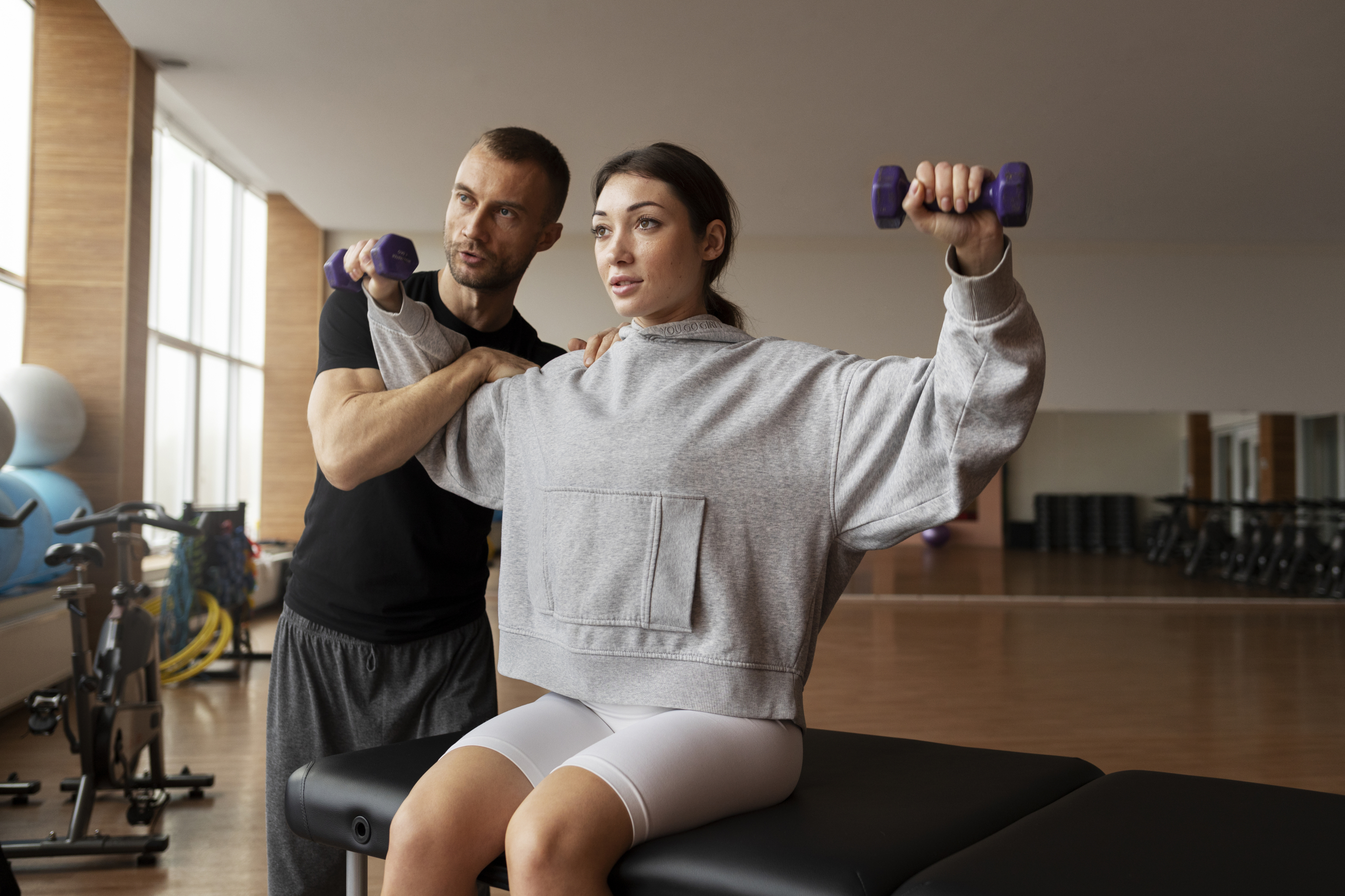 Patient doing physical rehabilitation helped by therapists scaled